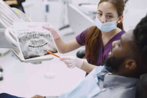 Dentist Reviewing X-Ray With Patient in toothology office