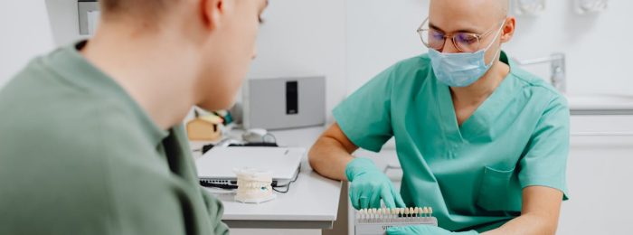 dentist showing patient shade guide or explaining composite options